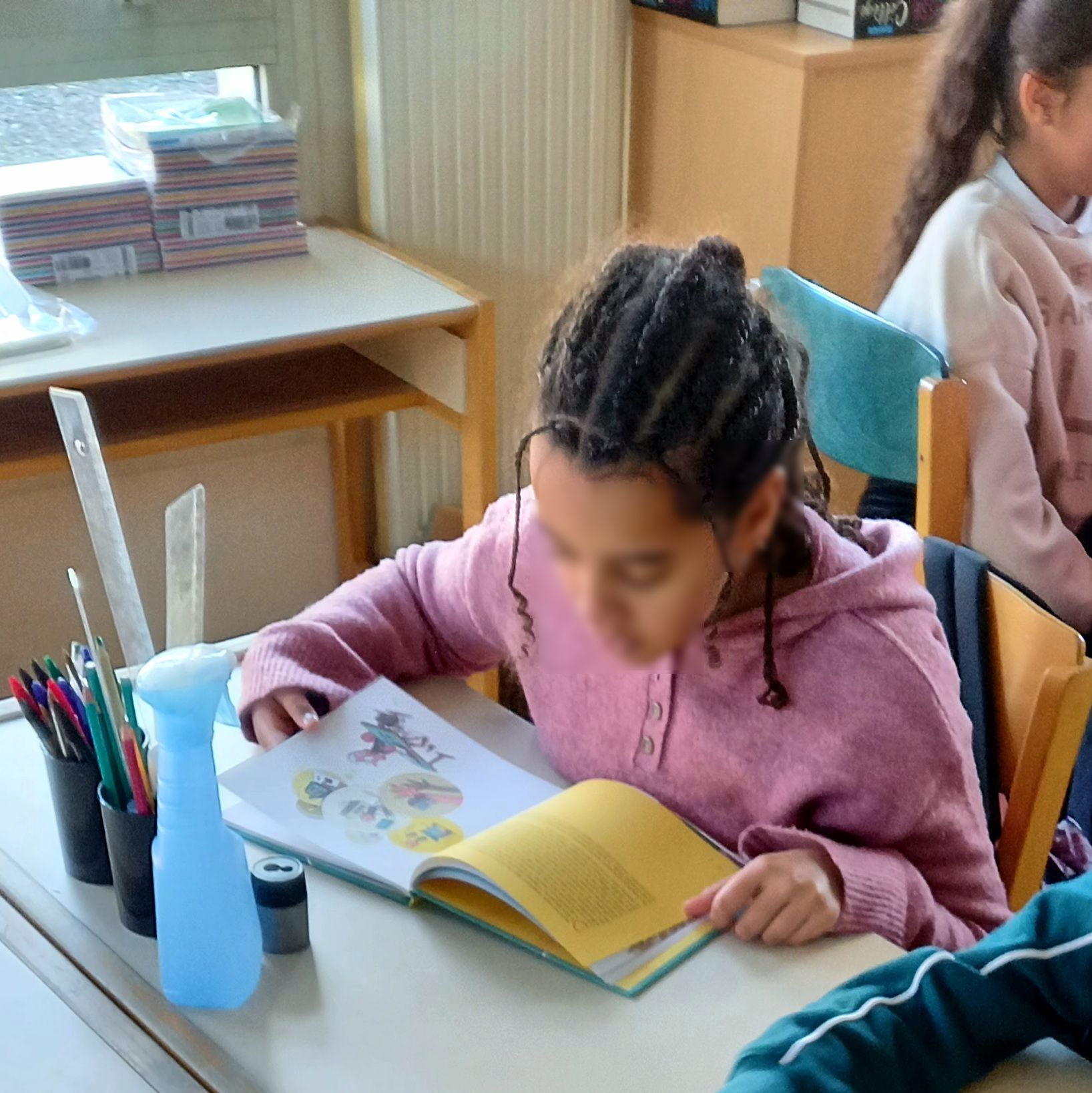 The Economics of Attention: Phone Bans and the Pupils Who Gain the Most Students learning in a phone-free classroom with smartphones put away, illustrating a study on classroom bans and academic performance